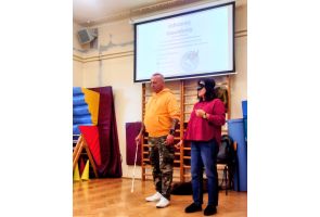 Instruktor uczy kobietę z zasłoniętymi oczami techniki posługiwania się białą laską podczas warsztatów Odlotowy Niewidomy.